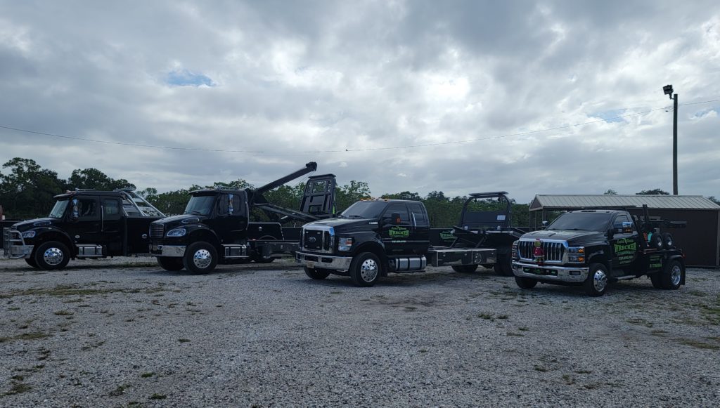 Central Florida Wrecker Service LLC tow trucks and flatbed trucks outside their warehouse