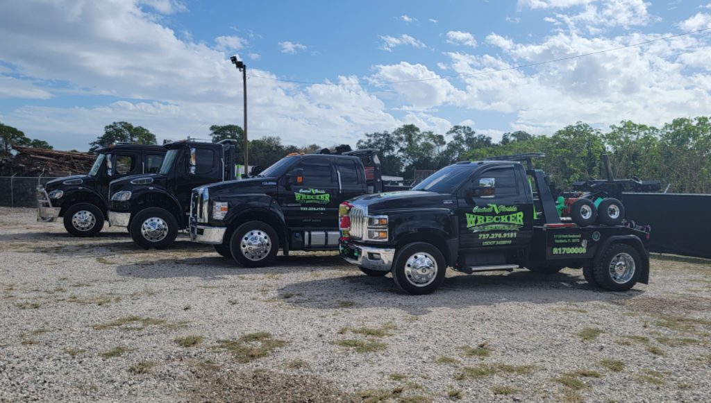 Central Florida Wrecker Service LLC tow trucks and flatbed trucks outside their warehouse