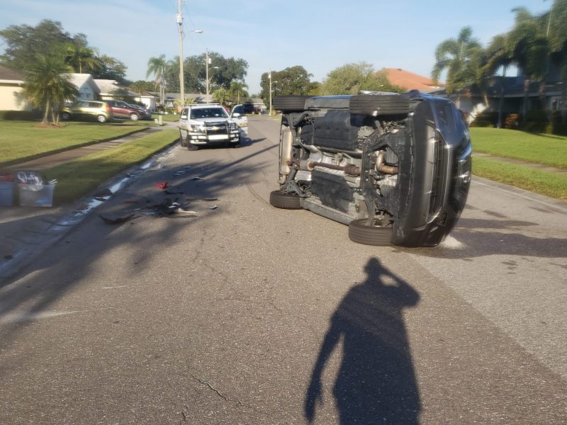 Black car tilted in the road beacause of accident